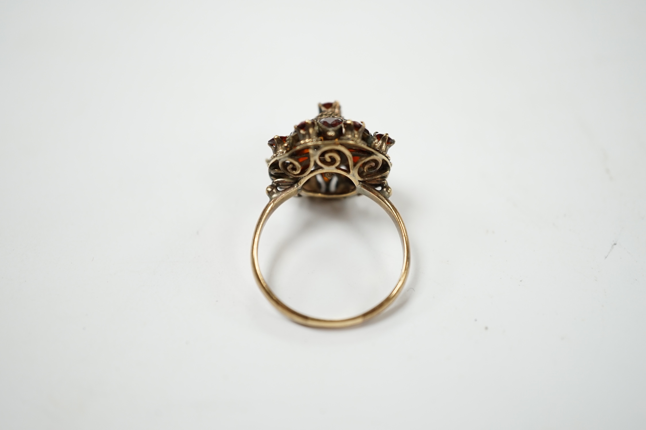 A 14k and garnet cluster set domed dress ring, size M/N, gross weight 3.4 grams. Condition - fair